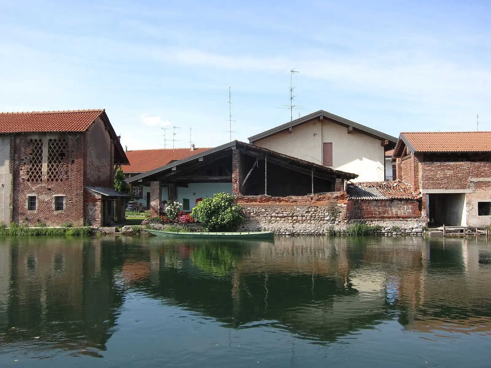 Docked boat on canal Naviglio Grande in Bernate Ticino (MI), Lombardy, Italy - 2020-05-24